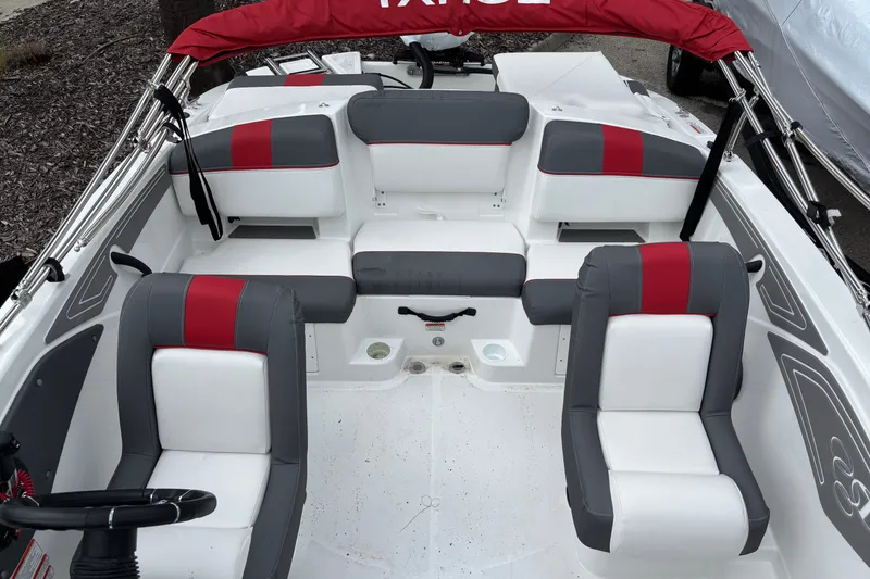 Slide: The Image of 2026 Tahoe T21 boat interior with gray and red seating, steering wheel visible. - 9