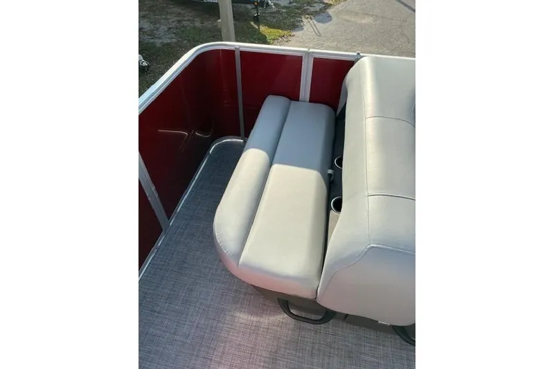 Slide: The Image of 2026 Sun Tracker Party Barge 18 DLX with comfortable seating and red paneling. - 8