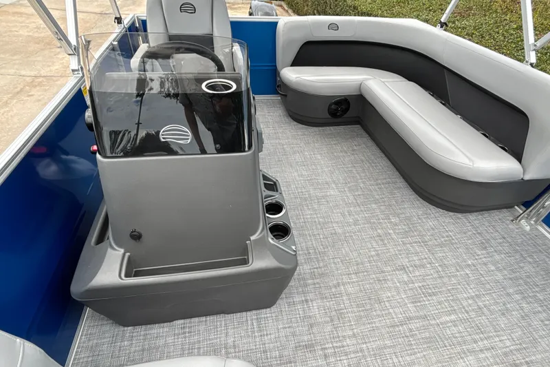 Slide: The Image of 2026 Sun Tracker Party Barge 16 DLX interior with gray seating and helm. - 15