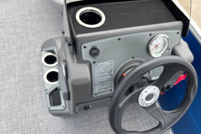 Slide: The Image of 2026 Sun Tracker Party Barge 16 DLX steering console with cup holders and gauge. - 19