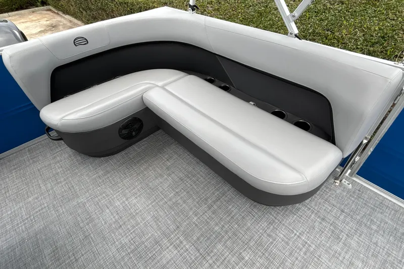 Slide: The Image of 2026 Sun Tracker Party Barge 16 DLX interior seating with gray upholstery and cup holders. - 13