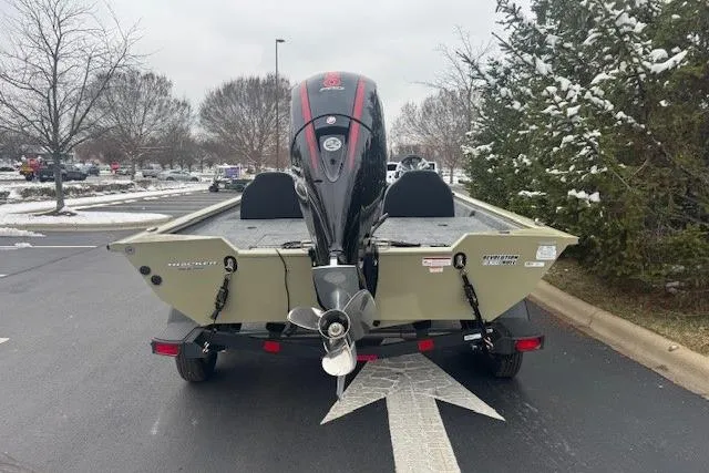 Slide: The Image of 2026 Tracker Pro Team 195 boat, rear view with motor, parked on snowy pavement. - 5