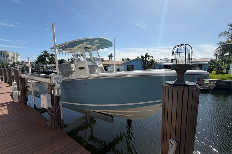 Slide: The Image of 2021 Cobia 262 Center Console boat docked on a sunny day. - 1