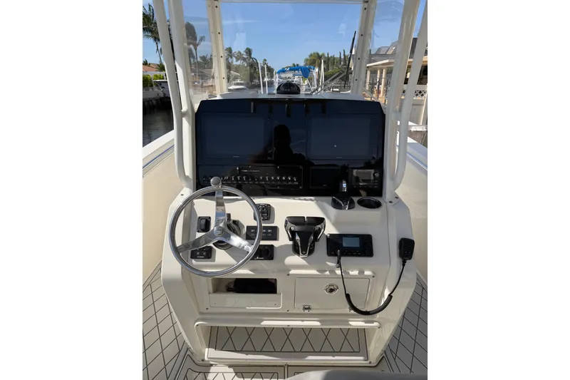 Slide: The Image of 2021 Cobia 262 Center Console boat dashboard with steering wheel and navigation controls. - 14
