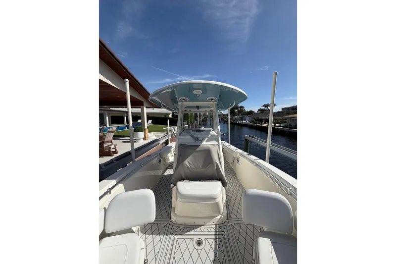 Slide: The Image of 2021 Cobia 262 Center Console boat docked by a waterfront home. - 22