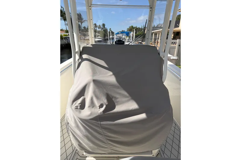Slide: The Image of 2021 Cobia 262 Center Console boat with covered helm station, docked in a sunny marina. - 4