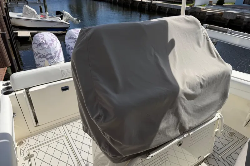 Slide: The Image of 2021 Cobia 262 Center Console boat with covered seating, docked by the water. - 5