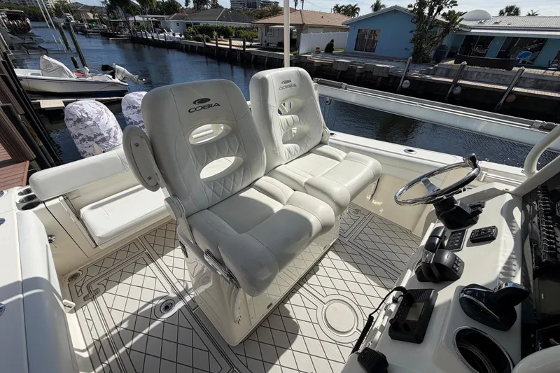Slide: The Image of 2021 Cobia 262 Center Console boat interior with white seating and steering wheel. - 7