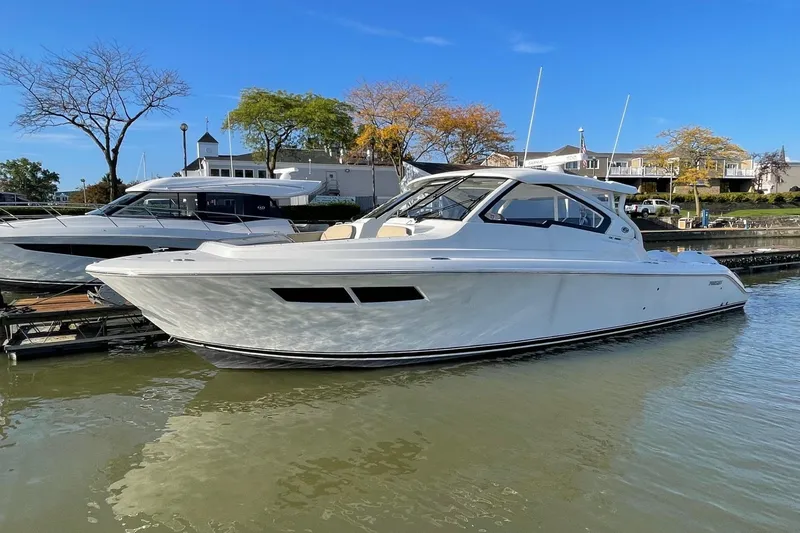 The Image of 2020 Pursuit DC 365 Dual Console boat docked in a marina under clear blue skies. - 0
