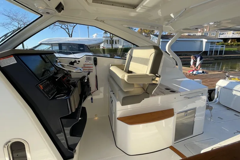 Slide: The Image of 2020 Pursuit DC 365 Dual Console interior with helm and seating, dockside view. - 11