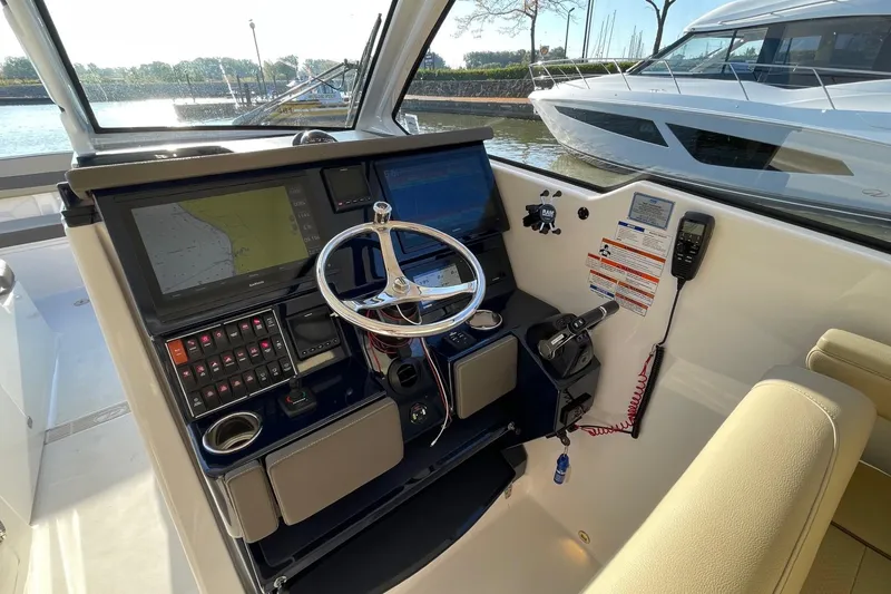 Slide: The Image of 2020 Pursuit DC 365 Dual Console helm with navigation screens and steering wheel. - 13