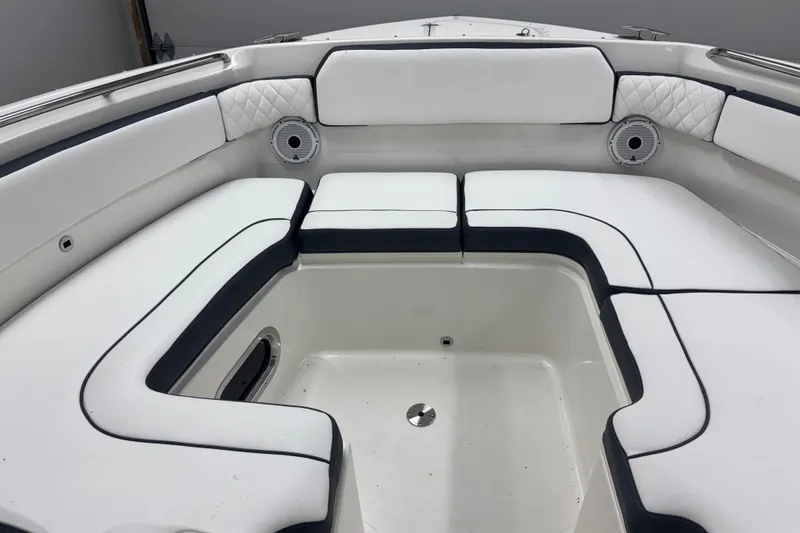 Slide: The Image of 2020 Pursuit DC 365 Dual Console boat interior with white cushioned seating and speakers. - 18