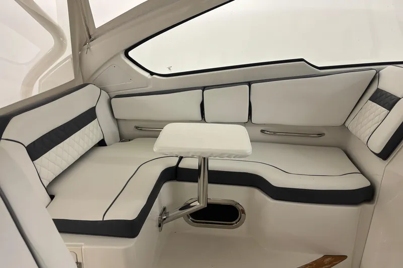 Slide: The Image of 2020 Pursuit DC 365 Dual Console interior with white seating and small table. - 20