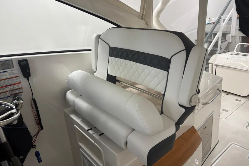 Slide: The Image of 2020 Pursuit DC 365 Dual Console boat interior with luxurious seating and control panel. - 24