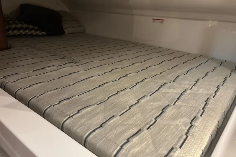 Slide: The Image of 2020 Pursuit DC 365 Dual Console cabin with striped bedding and pillows. - 39