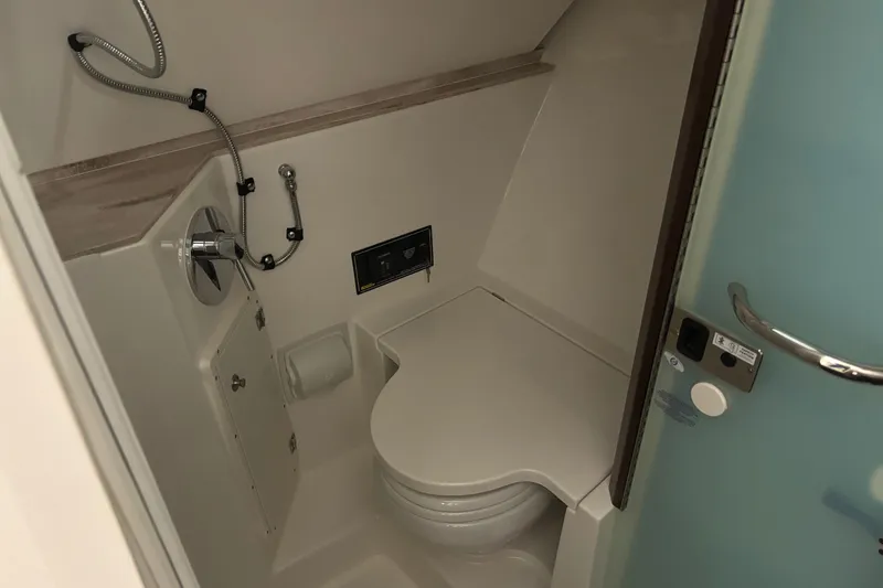 Slide: The Image of 2020 Pursuit DC 365 Dual Console boat bathroom interior with toilet and shower. - 44