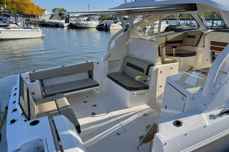 Slide: The Image of 2020 Pursuit DC 365 Dual Console boat interior with seating, docked in a marina. - 5