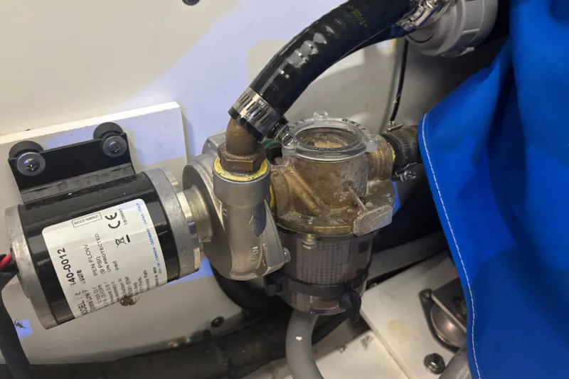 Slide: The Image of Engine compartment of 2020 Pursuit DC 365 Dual Console with visible pump and hoses. - 50