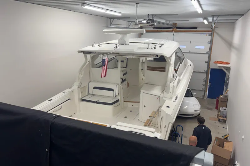 Slide: The Image of 2020 Pursuit DC 365 Dual Console boat in a garage with an American flag. - 62
