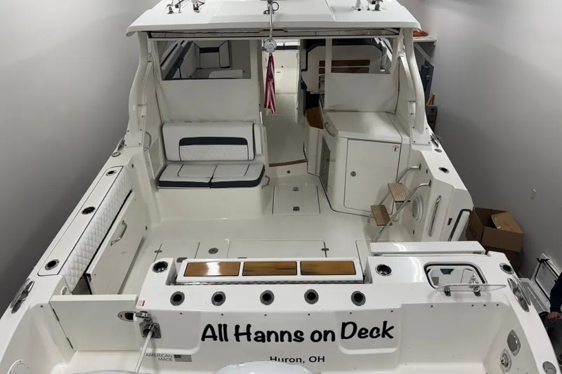 Slide: The Image of 2020 Pursuit DC 365 Dual Console boat interior, named "All Hanns on Deck," in a garage. - 63