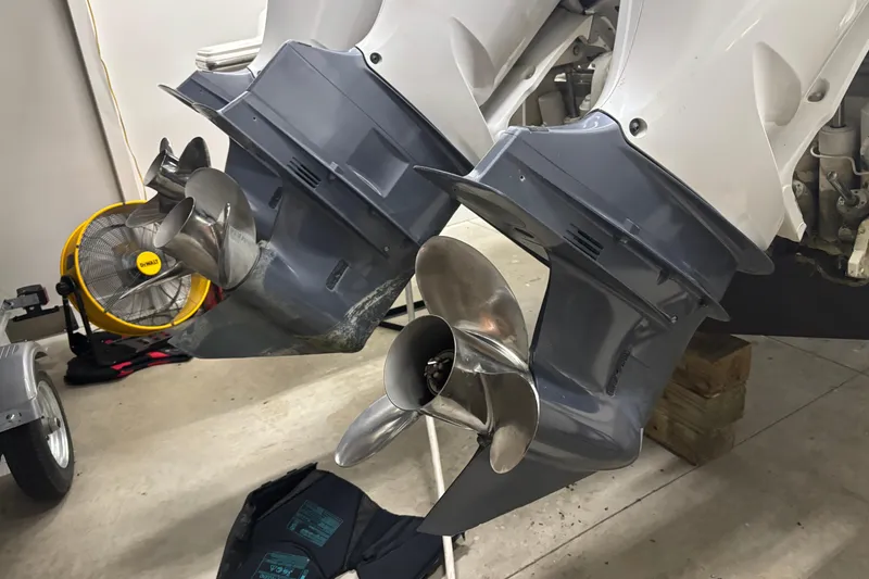 Slide: The Image of 2020 Pursuit DC 365 Dual Console boat propellers in a garage setting. - 67
