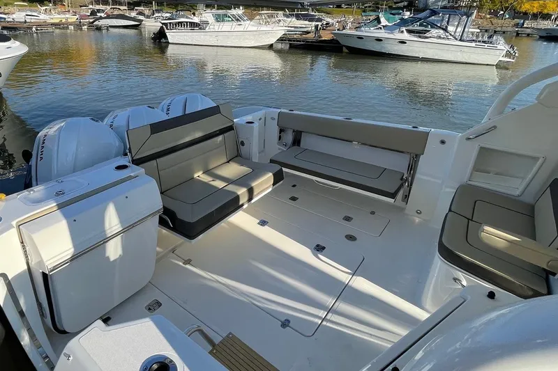 Slide: The Image of 2020 Pursuit DC 365 Dual Console boat interior with seating, docked at marina. - 7