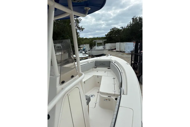 Slide: The Image of 2023 Sea Chaser 24 HFC boat, white interior, docked outdoors under cloudy sky. - 4