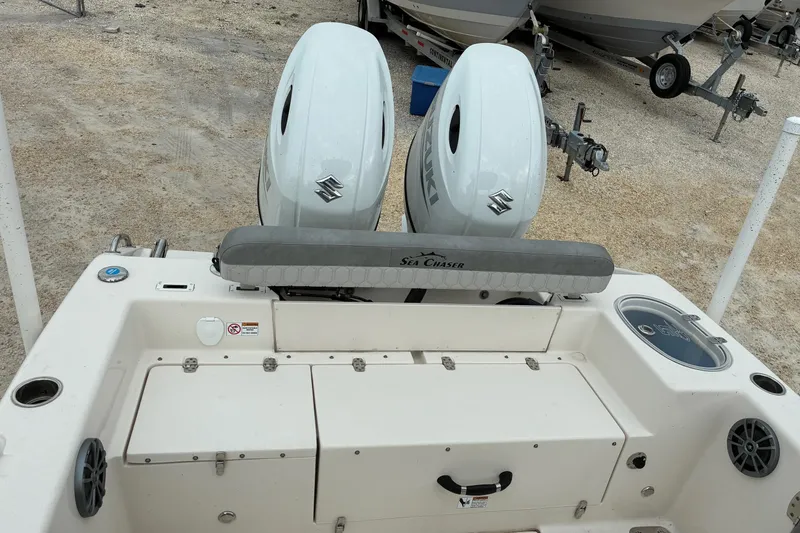 Slide: The Image of 2023 Sea Chaser 24 HFC boat with dual Suzuki engines, parked on gravel. - 5
