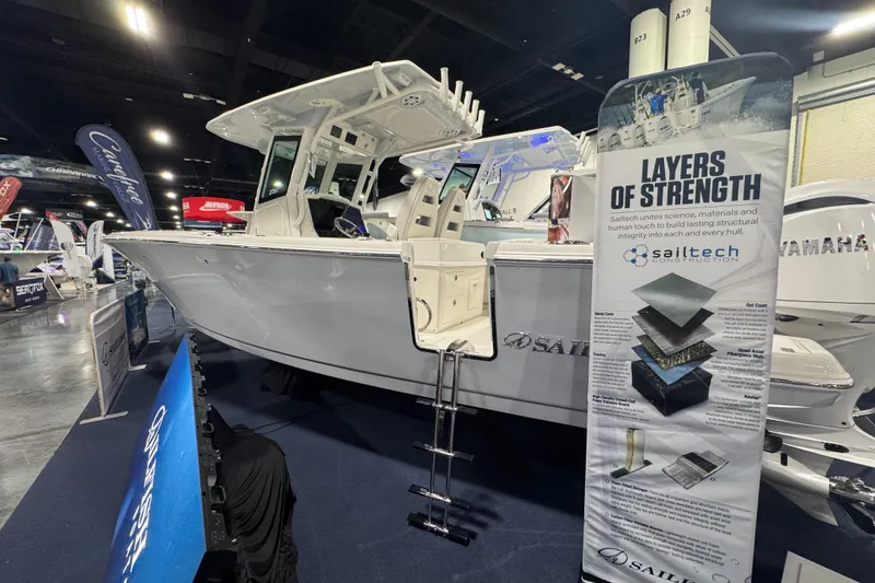 Slide: The Image of 2026 Sailfish 272 CC boat displayed at an indoor exhibition with informational banner. - 1
