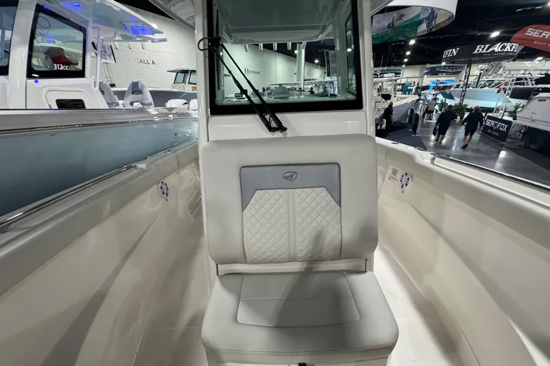 Slide: The Image of 2026 Sailfish 272 CC boat interior with cushioned seating at a boat show. - 7