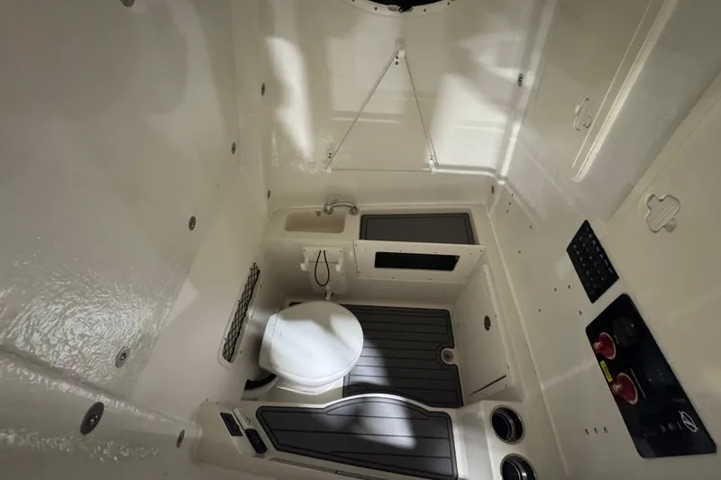 Slide: The Image of Interior of 2026 Sailfish 272 CC boat featuring compact bathroom with toilet and sink. - 9