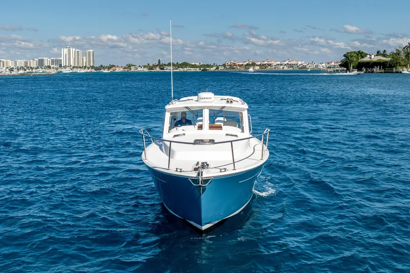 Slide: The Image of 2025 MJM 35 boat cruising on blue ocean near city skyline. - 12