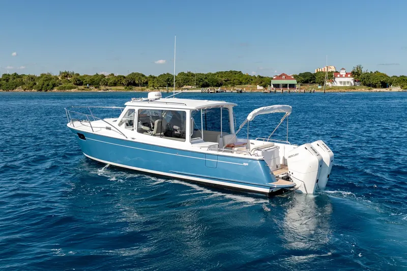 Slide: The Image of 2025 MJM 35 boat cruising on blue waters near a scenic shoreline. - 15