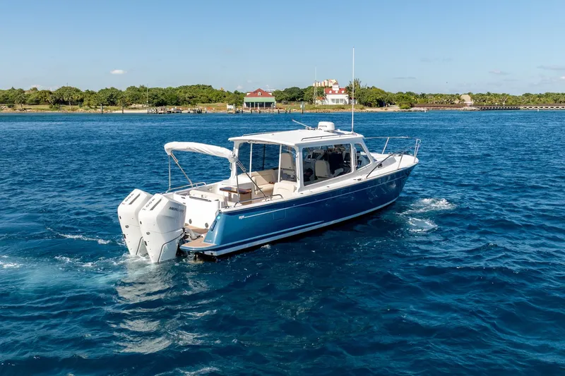 Slide: The Image of 2025 MJM 35 boat cruising on blue water near a scenic shoreline. - 16