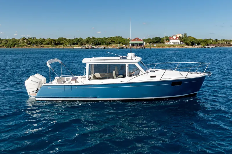 Slide: The Image of 2025 MJM 35 boat cruising on blue water near a scenic shoreline. - 18