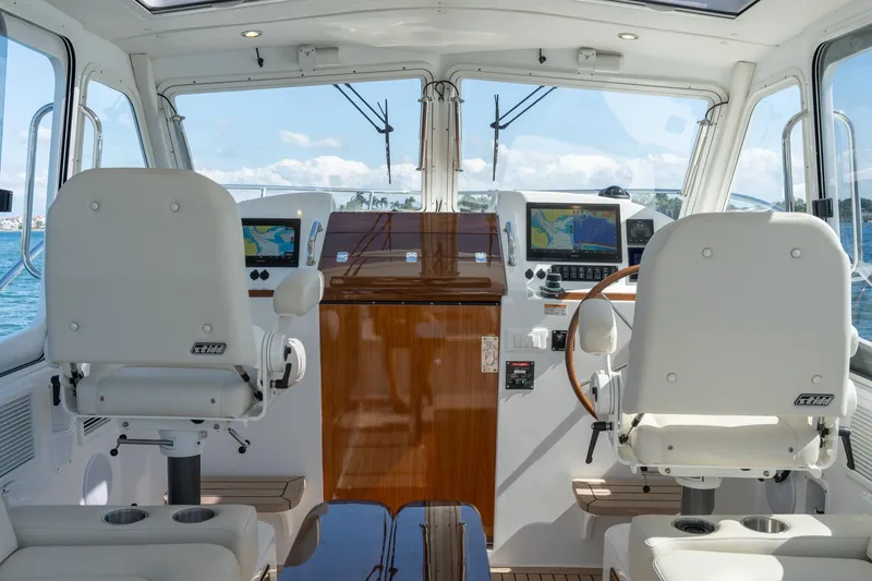 Slide: The Image of 2025 MJM 35 boat interior with dual helm seats and navigation displays. - 23