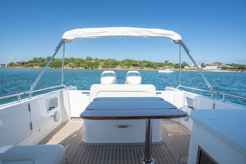 Slide: The Image of 2025 MJM 35 boat deck with seating, table, and scenic water view. - 30