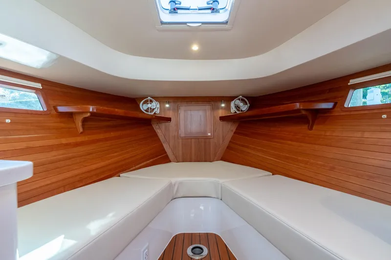 Slide: The Image of 2025 MJM 35 boat interior with wooden paneling and cushioned seating. - 33