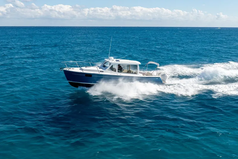 Slide: The Image of 2025 MJM 35 boat cruising on open blue ocean under clear sky. - 7