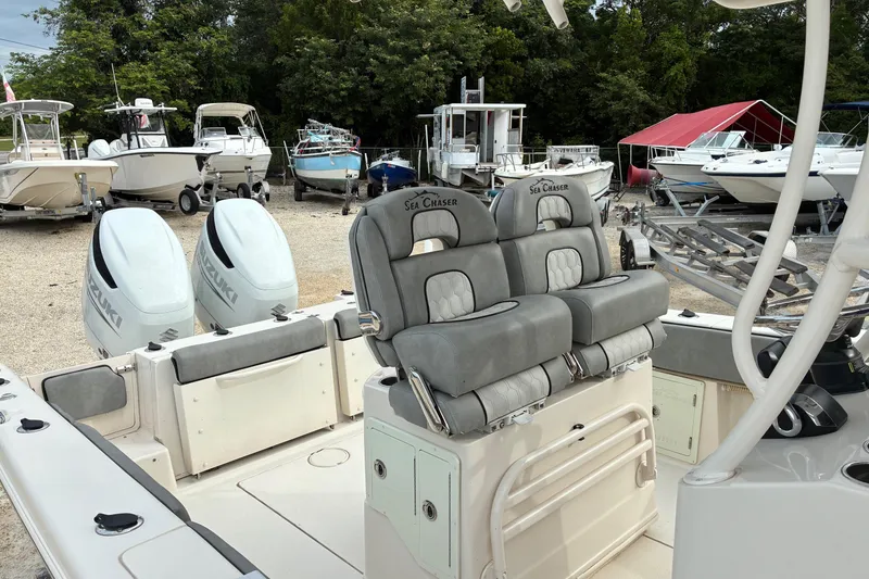 Slide: The Image of 2023 Sea Chaser 27 HFC CC boat with dual Suzuki engines in a marina. - 4