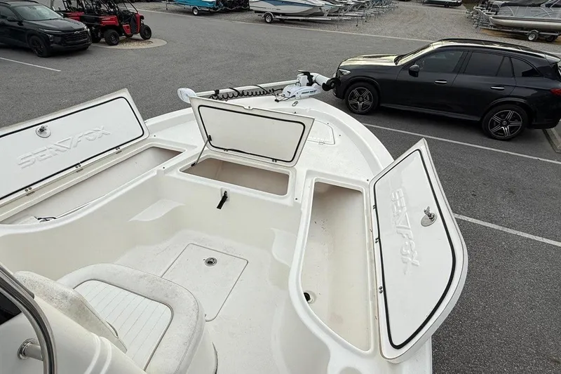 Slide: The Image of 2015 Sea Fox 200 Viper boat with open storage compartments in a parking lot. - 16