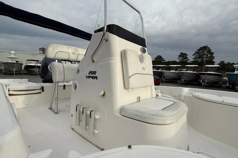 Slide: The Image of 2015 Sea Fox 200 Viper boat interior with seating and console, parked outdoors. - 5