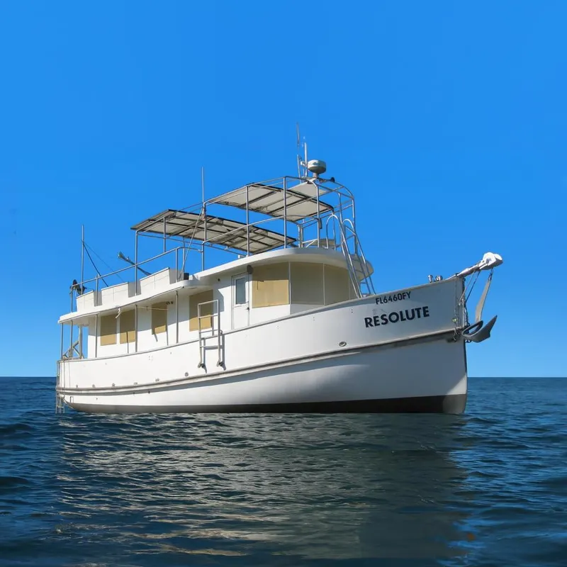 Slide: The Image of 1987 Custom Pilgrim Tribute boat named "Resolute" on calm blue water under clear sky. - 0