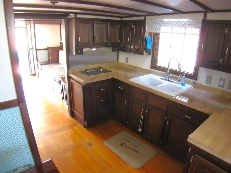 Slide: The Image of 1987 Custom Pilgrim Tribute kitchen with dark wood cabinets, dual sink, and stove. - 10