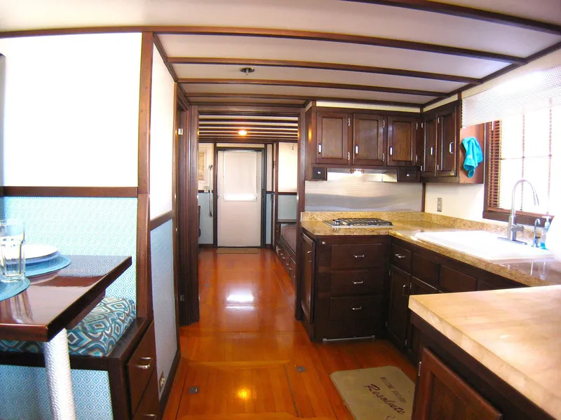 Slide: The Image of Interior of 1987 Custom Pilgrim Tribute boat with wooden cabinetry and modern kitchen amenities. - 12