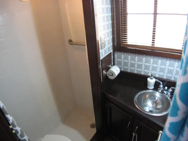 Slide: The Image of Compact bathroom in 1987 Custom Pilgrim Tribute with shower, sink, and window blinds. - 14