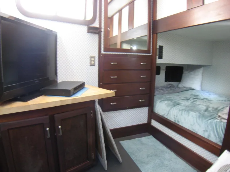 Slide: The Image of Interior of 1987 Custom Pilgrim Tribute with TV, bunk bed, and wooden cabinetry. - 24