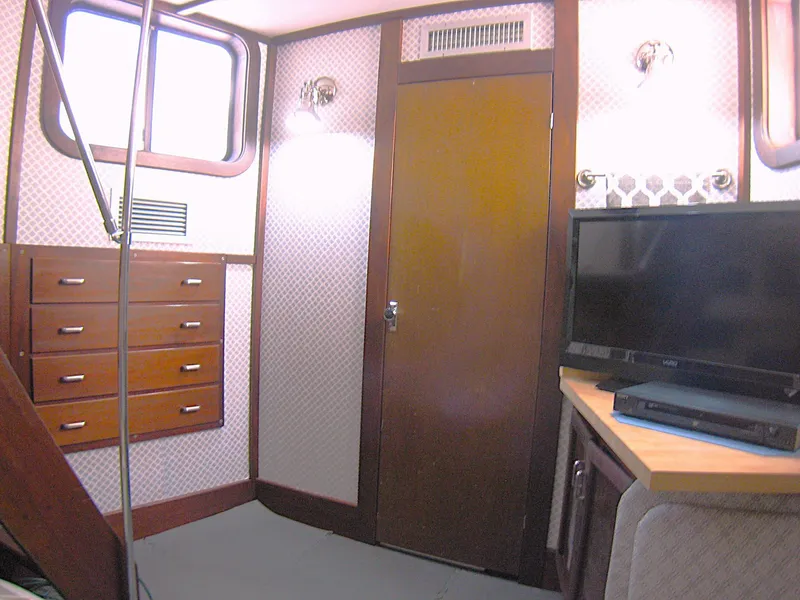 Slide: The Image of Interior of 1987 Custom Pilgrim Tribute boat with TV, drawers, and wood paneling. - 26