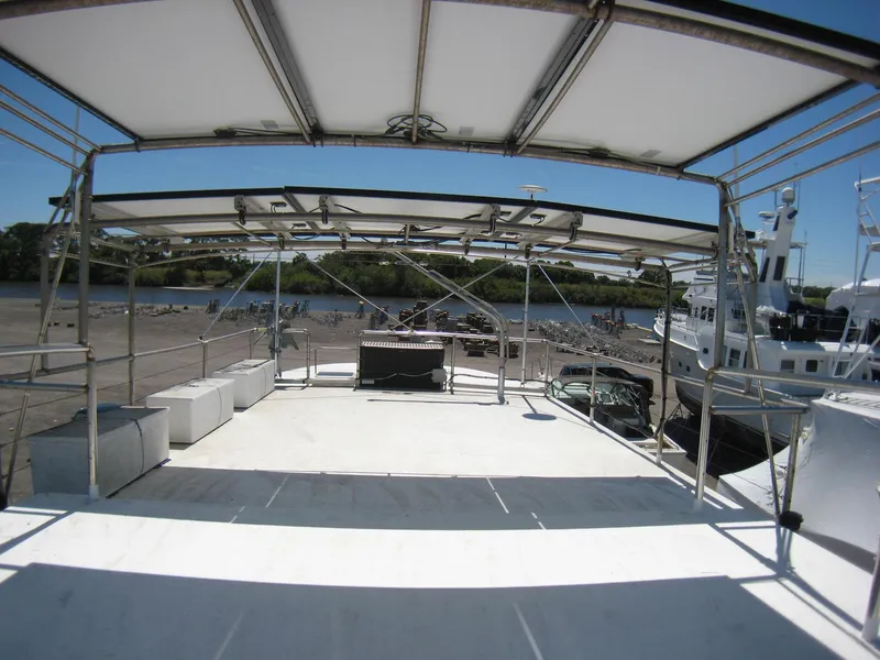 Slide: The Image of Custom 1987 Pilgrim Tribute boat deck with canopy, docked near a riverbank. - 35