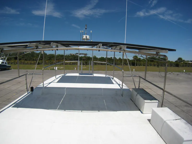 Slide: The Image of 1987 Custom Pilgrim Tribute boat with spacious deck and canopy, set against a clear blue sky. - 36